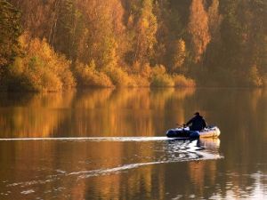 Рыбак в лодке осенью